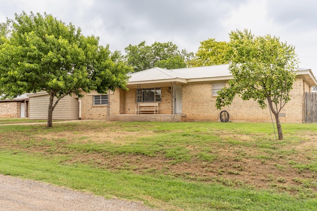 508 S Austin St, Shamrock, TX 79079 - view of front facade with a front lawn, brick siding, an attached garage, and a metal roof