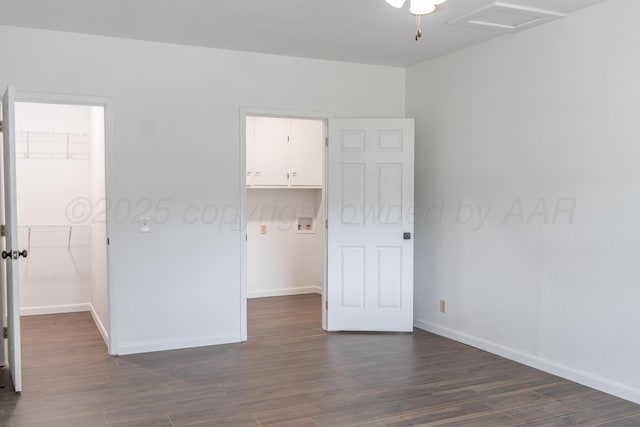 508 S Austin St, Shamrock, TX 79079 - unfurnished bedroom featuring a walk in closet, a closet, and dark wood-type flooring