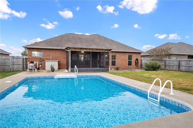 view of swimming pool featuring a sunroom, a patio area, and a lawn