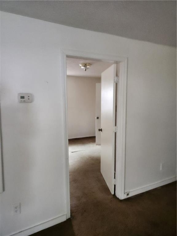 180 Carstens St, Mobile, AL 36617 - corridor featuring dark carpet and baseboards