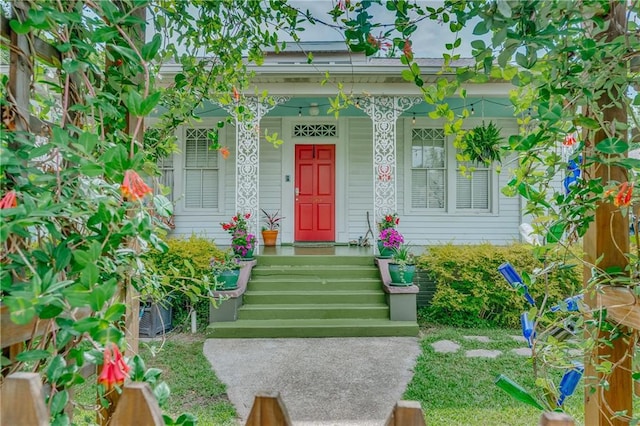 view of exterior entry featuring covered porch