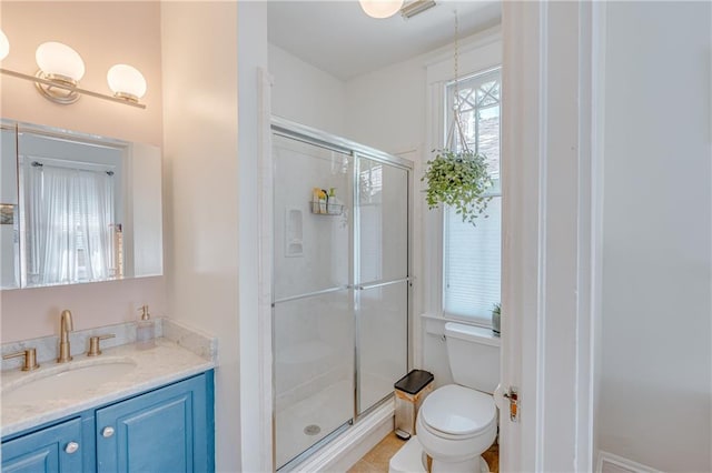 bathroom featuring toilet, a shower stall, and vanity
