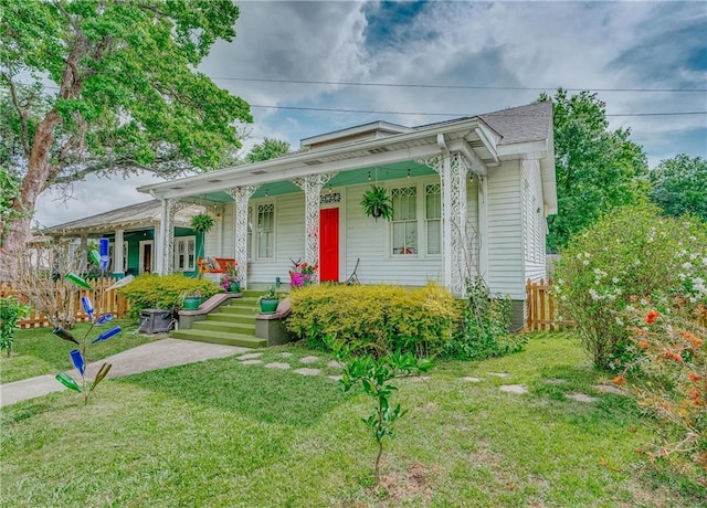 view of front of property with fence, covered porch, and a front yard