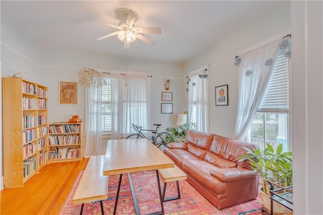 living area with a ceiling fan and light wood-style flooring