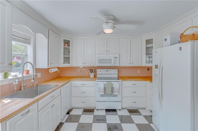 kitchen featuring white appliances, tile patterned floors, a sink, and light countertops