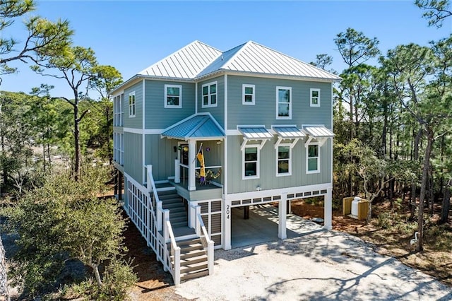 204 Magnolia Ct, Dauphin Island, AL 36528 - rear view of property with stairway, a standing seam roof, a carport, dirt driveway, and metal roof