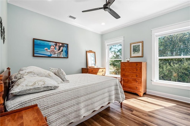 204 Magnolia Ct, Dauphin Island, AL 36528 - bedroom with visible vents, ceiling fan, baseboards, ornamental molding, and wood finished floors