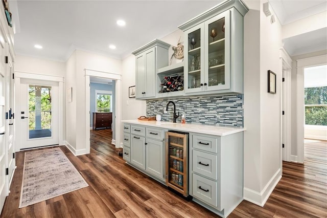 bar with beverage cooler, decorative backsplash, a healthy amount of sunlight, and ornamental molding