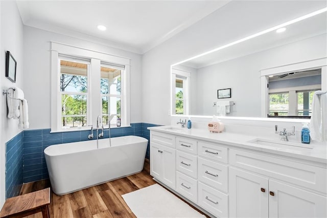 204 Magnolia Ct, Dauphin Island, AL 36528 - full bathroom featuring a sink, a soaking tub, wood finished floors, and double vanity