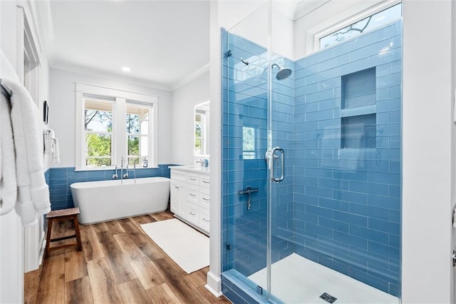 204 Magnolia Ct, Dauphin Island, AL 36528 - bathroom with wood finished floors, a stall shower, ornamental molding, a freestanding bath, and tile walls