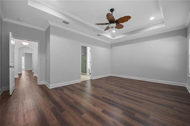 empty room featuring ornamental molding, ceiling fan, dark hardwood / wood-style flooring, and a tray ceiling