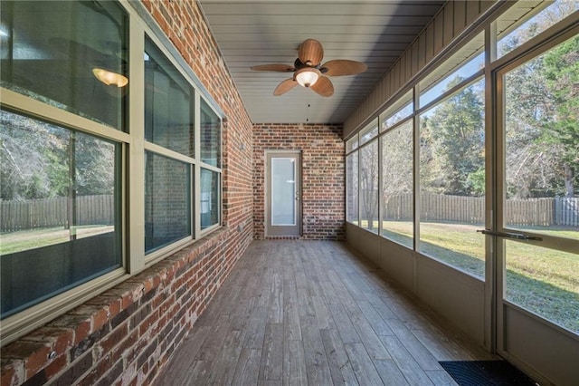 unfurnished sunroom featuring a wealth of natural light and ceiling fan