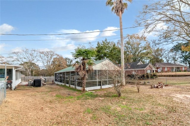 view of yard with central AC and a sunroom