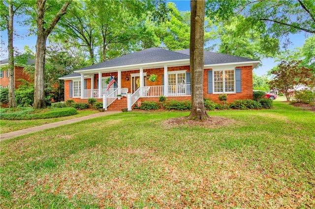 view of front of property with a porch, a front lawn, and brick siding