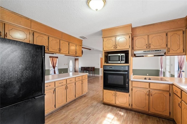 kitchen with a textured ceiling, light hardwood / wood-style flooring, and black appliances