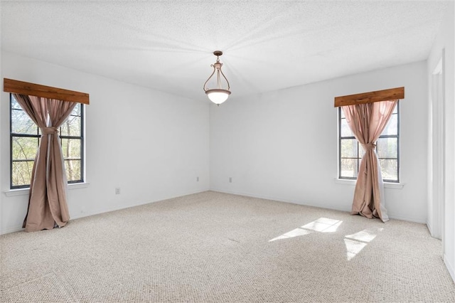 carpeted empty room with a textured ceiling