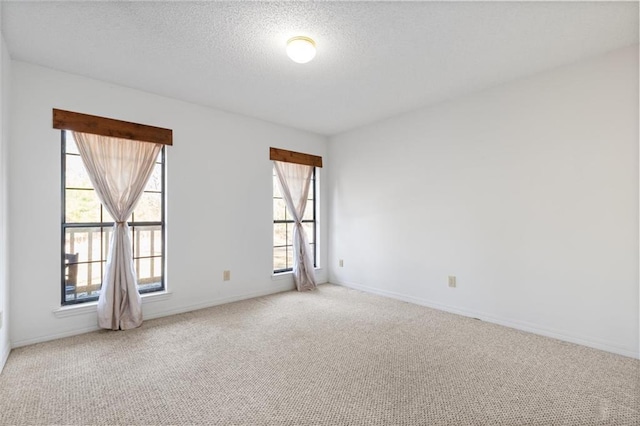 empty room with carpet and a textured ceiling