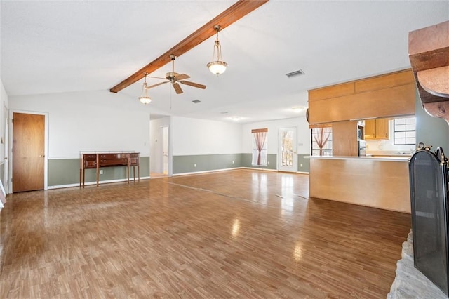 unfurnished living room with dark wood-type flooring, ceiling fan, and vaulted ceiling with beams