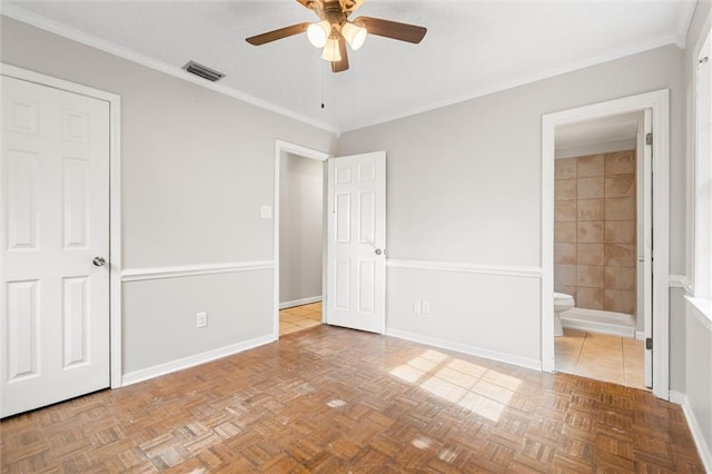 unfurnished bedroom with crown molding, parquet flooring, connected bathroom, and ceiling fan