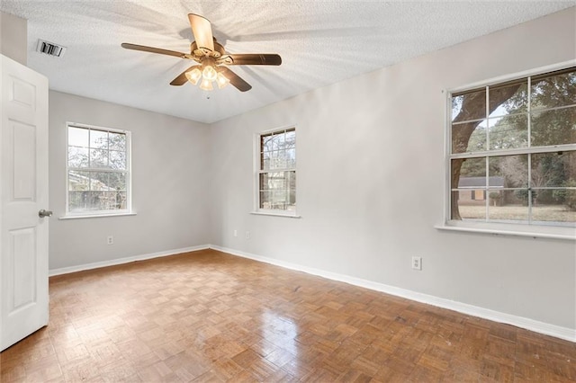 unfurnished room featuring ceiling fan, parquet flooring, and a textured ceiling