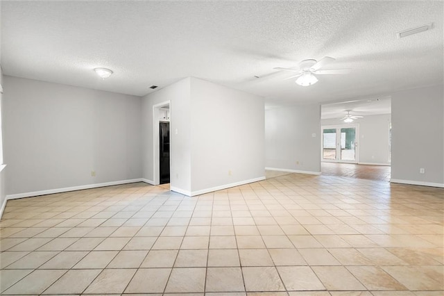 tiled empty room featuring a textured ceiling and ceiling fan