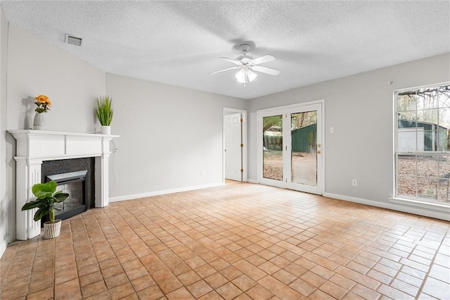 unfurnished living room with a textured ceiling and ceiling fan