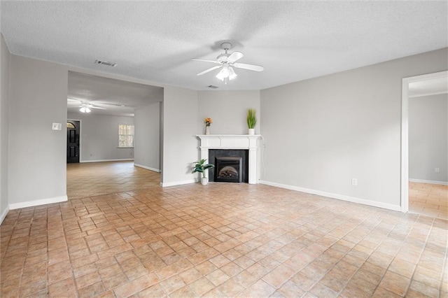 unfurnished living room with a textured ceiling and ceiling fan