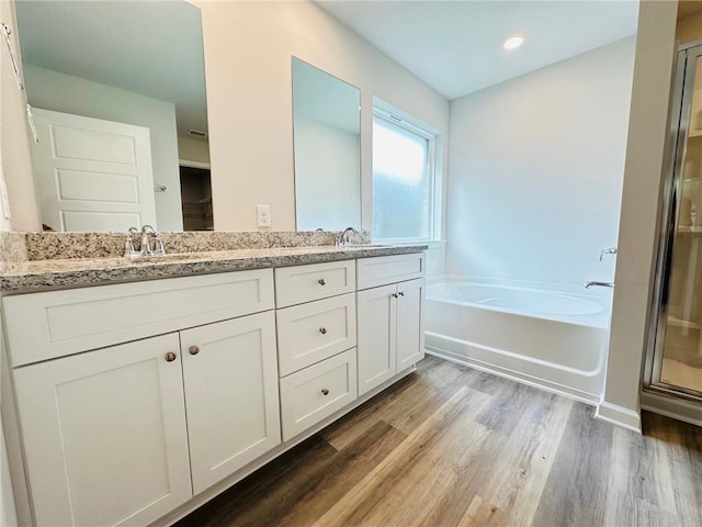 bathroom featuring vanity, plus walk in shower, and hardwood / wood-style floors