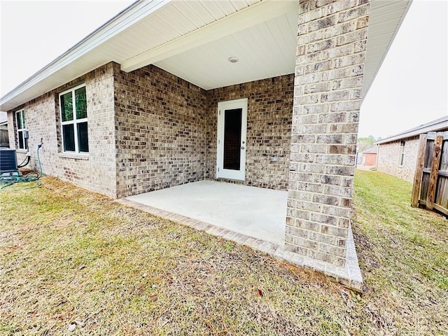 doorway to property featuring central AC unit, a yard, and a patio