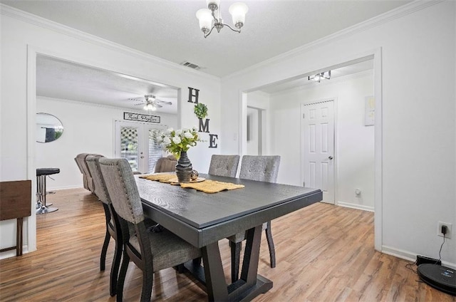 dining room featuring ceiling fan with notable chandelier, ornamental molding, hardwood / wood-style flooring, and french doors