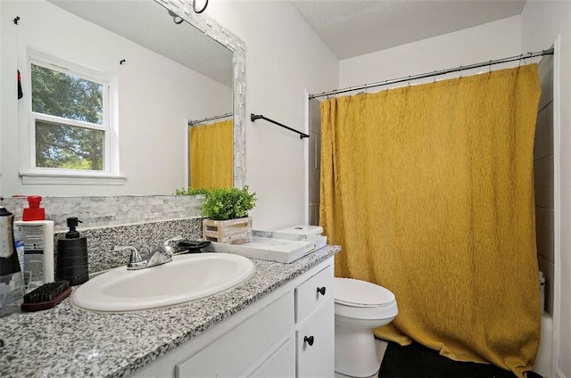 bathroom featuring a shower with shower curtain, toilet, and vanity