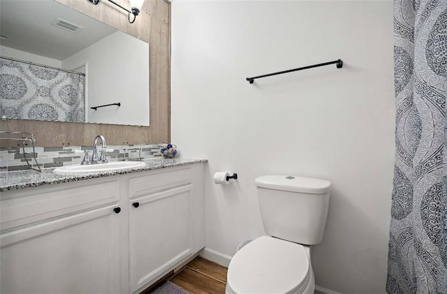 bathroom featuring wood-type flooring, toilet, and vanity