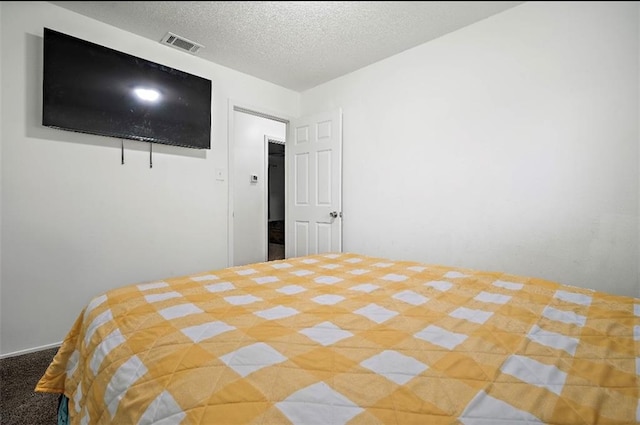 bedroom with light colored carpet and a textured ceiling