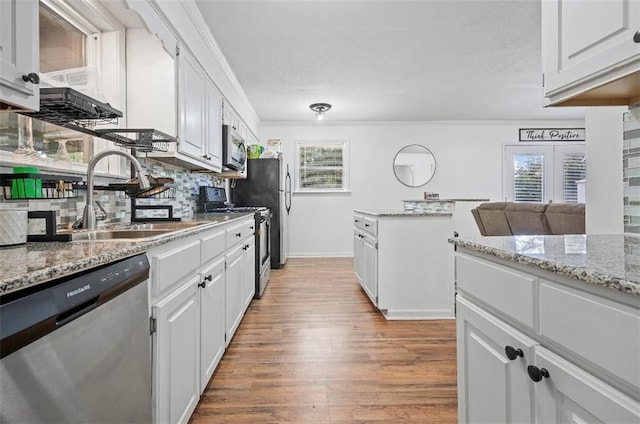 kitchen featuring ornamental molding, light hardwood / wood-style flooring, white cabinetry, and stainless steel appliances