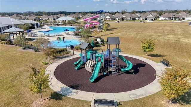 view of playground featuring a community pool and a yard