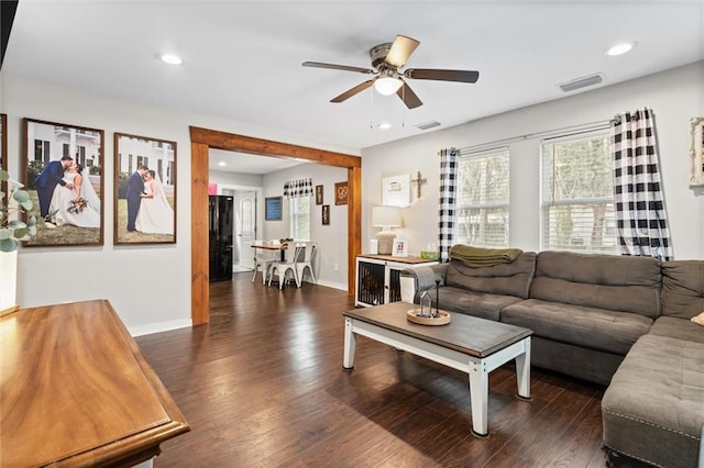 living room with dark hardwood / wood-style floors and ceiling fan