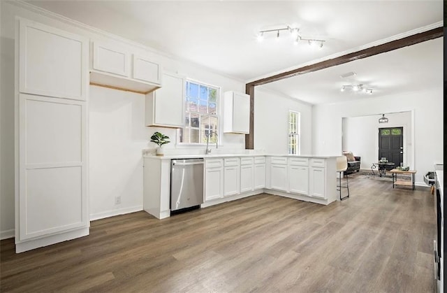 kitchen with white cabinetry, hardwood / wood-style floors, stainless steel dishwasher, and kitchen peninsula