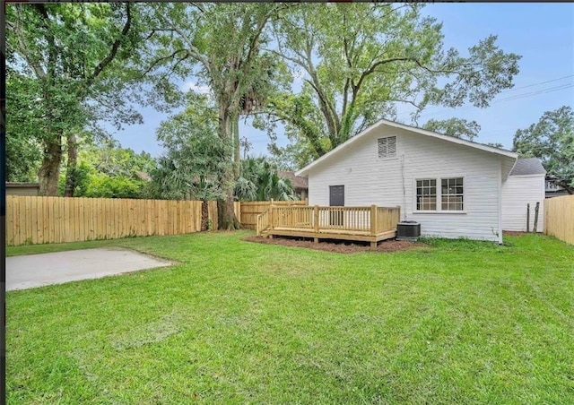 rear view of property featuring a wooden deck, a patio area, a lawn, and cooling unit