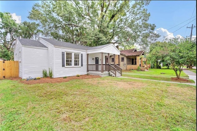 ranch-style house featuring covered porch and a front lawn