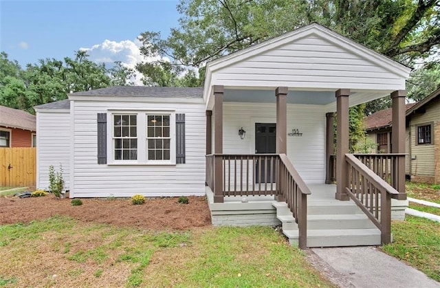 bungalow-style home with a front lawn and covered porch