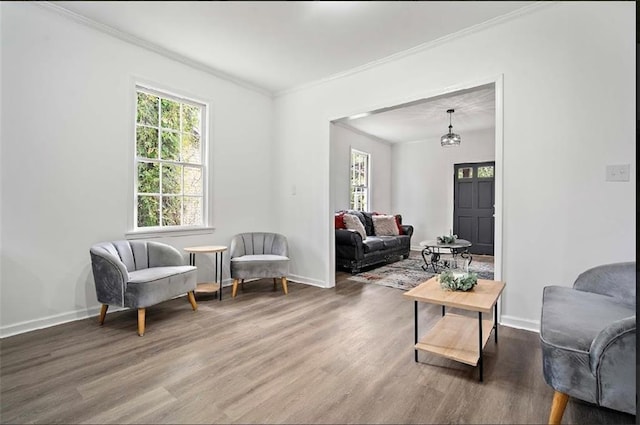 living area featuring crown molding and hardwood / wood-style flooring