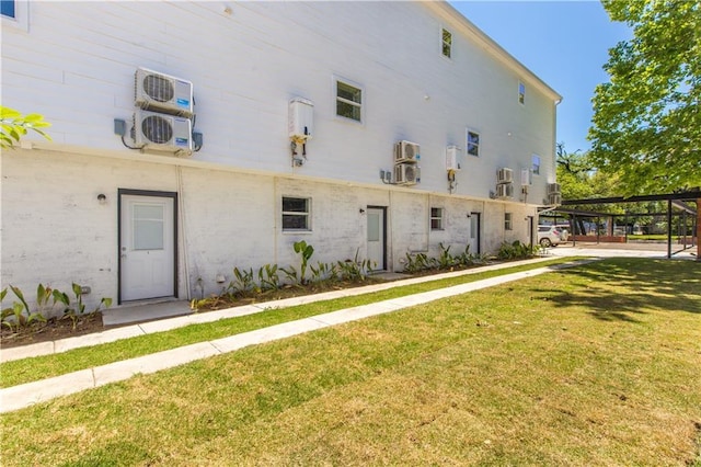 exterior space with ac unit and a yard