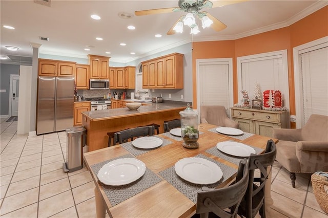 tiled dining room featuring crown molding, sink, and ceiling fan