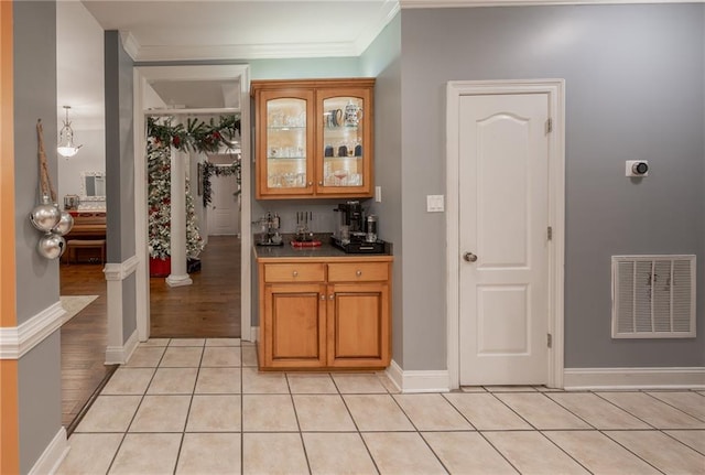 bar featuring light tile patterned floors and ornamental molding