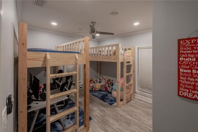 bedroom featuring hardwood / wood-style floors, ceiling fan, and ornamental molding