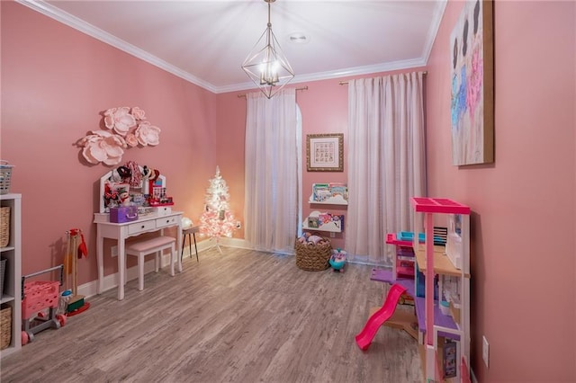 playroom featuring wood-type flooring, an inviting chandelier, and crown molding