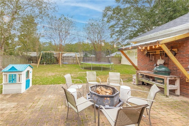 view of patio / terrace featuring a playground, an outdoor fire pit, and a trampoline