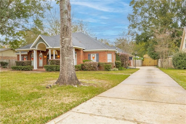 view of front of home featuring covered porch and a front lawn