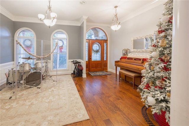 entryway with hardwood / wood-style floors, a notable chandelier, and ornamental molding