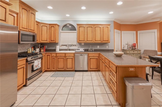 kitchen featuring sink, backsplash, crown molding, light tile patterned floors, and appliances with stainless steel finishes